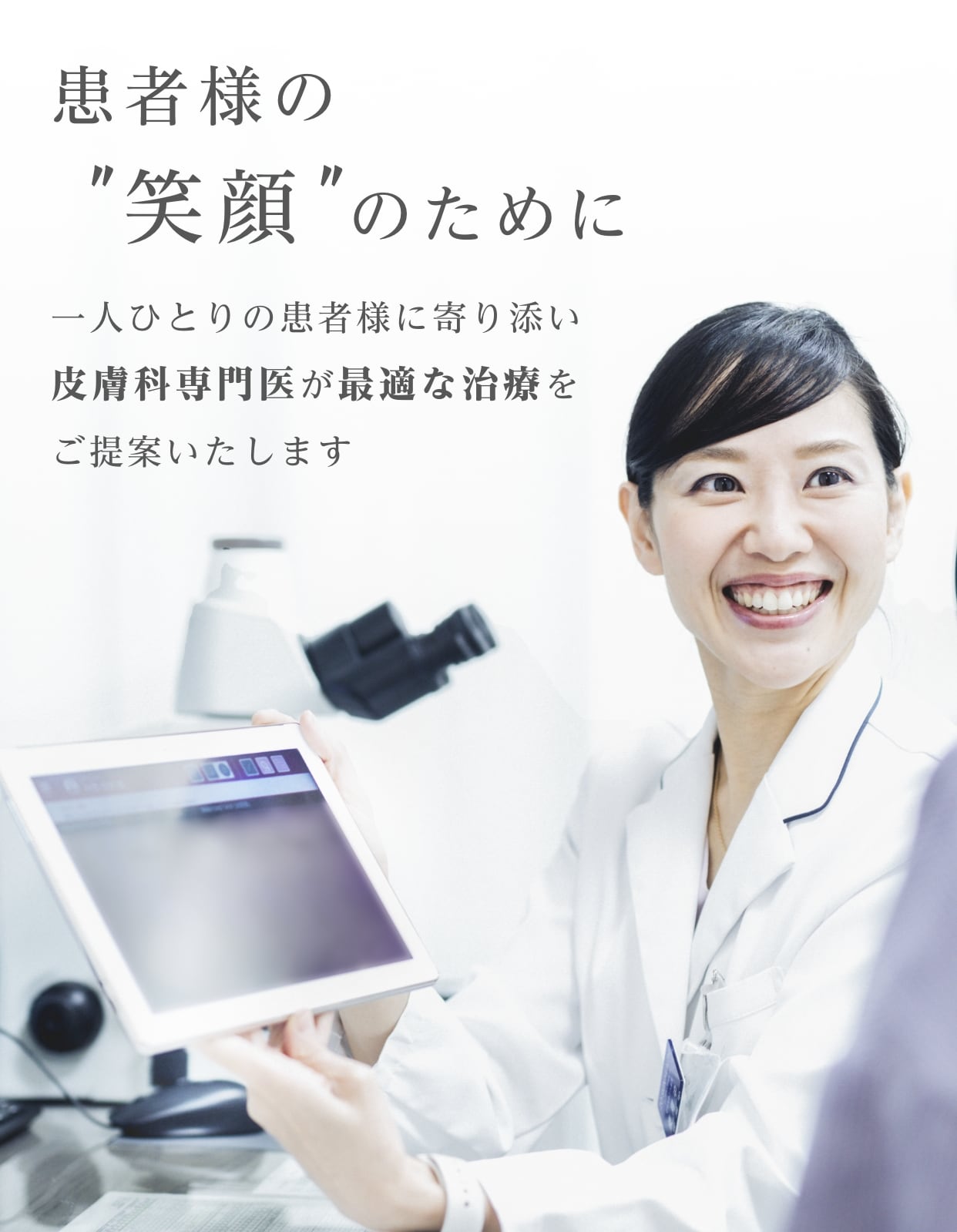 タブレットを持つ笑顔の女性医師が患者様と話す様子